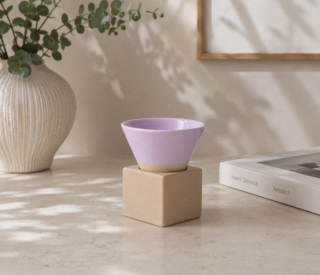 Lila espressokopje met vierkant blokje van naturel klei op een lichte tafel