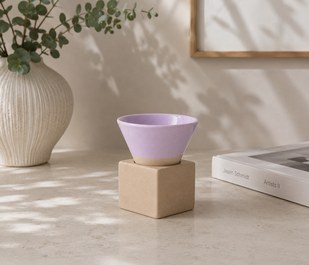Lila espressokopje met vierkant blokje van naturel klei op een lichte tafel